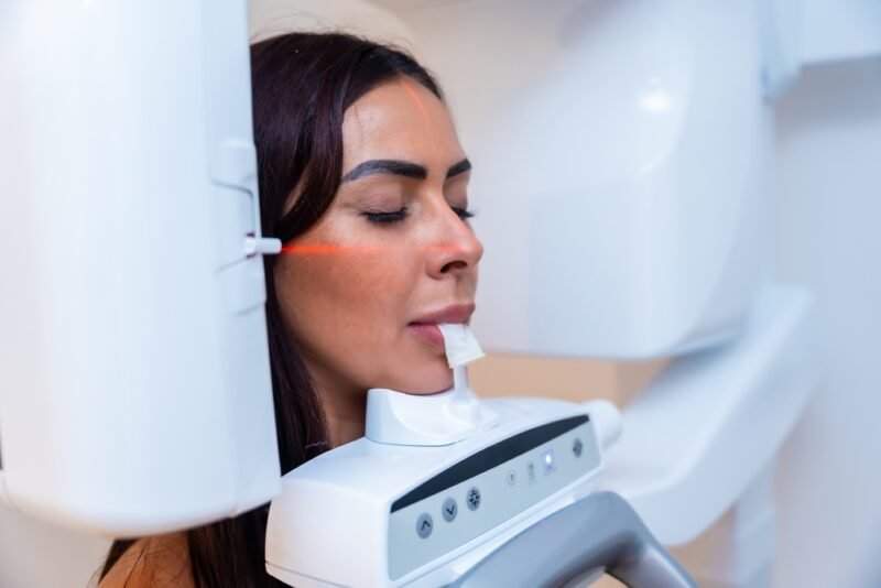 Patient undergoing a CBCT scan before dental implant surgery